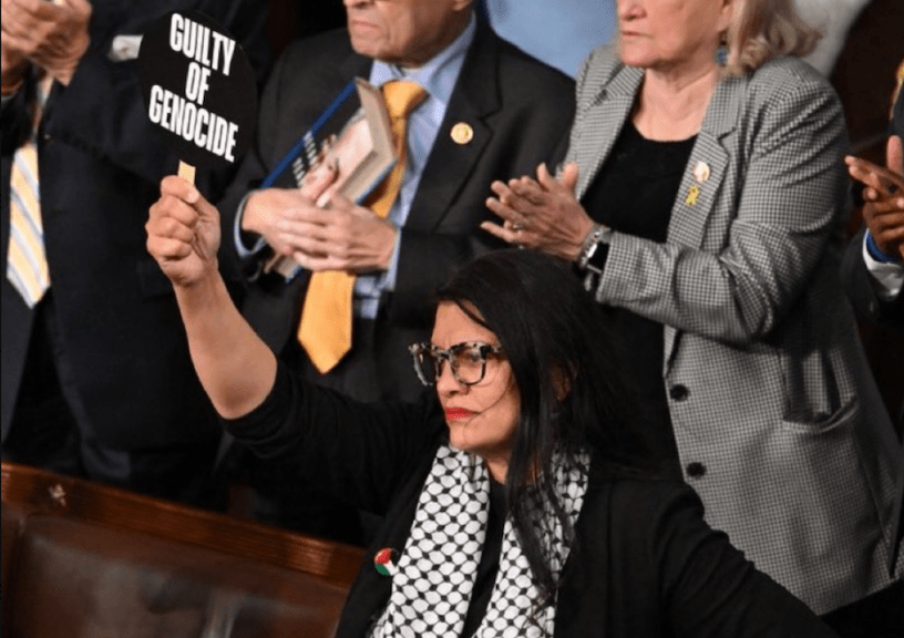 Rashida Tlaib holds a sign saying "guilty of genocide" during Netanyahu's speech.